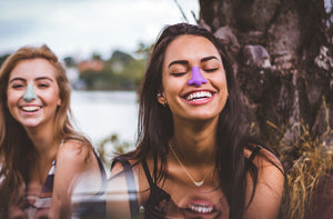 Two women smiling with Noz reef safe sunscreen out by a lake. 